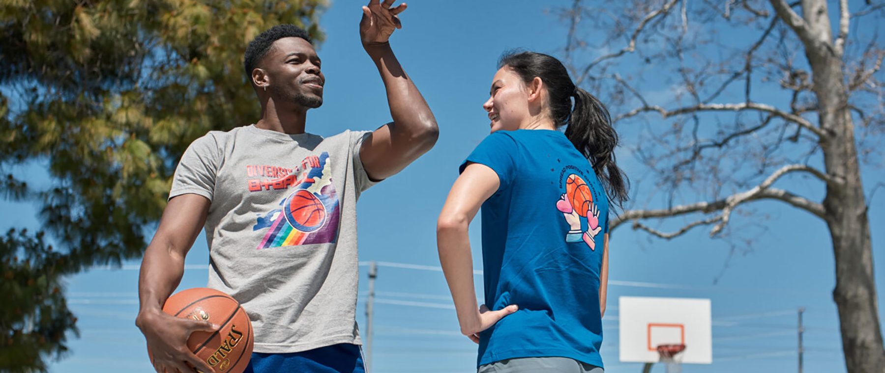 A man and a woman pause during a game of basketball in a promotional image by Crowd for a Spreadshop sustainability campaign.